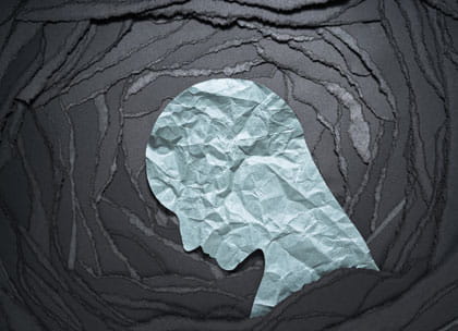 Crumpled paper figure surrounded by dark background